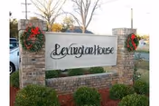 Brick entrance sign reading Lexington House with wreaths and manicured shrubs.