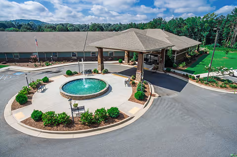Aerial view of Oaks at Hampton entrance with circular fountain and landscaped roundabout.