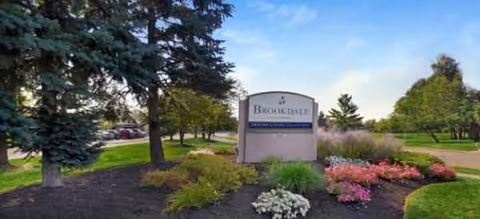Brookdale Kettering exterior building frontage with landscaped beds and trees.