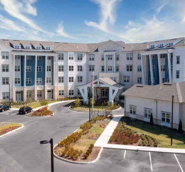 Exterior of The Summit of Germantown, a modern senior living community with landscaped driveway.