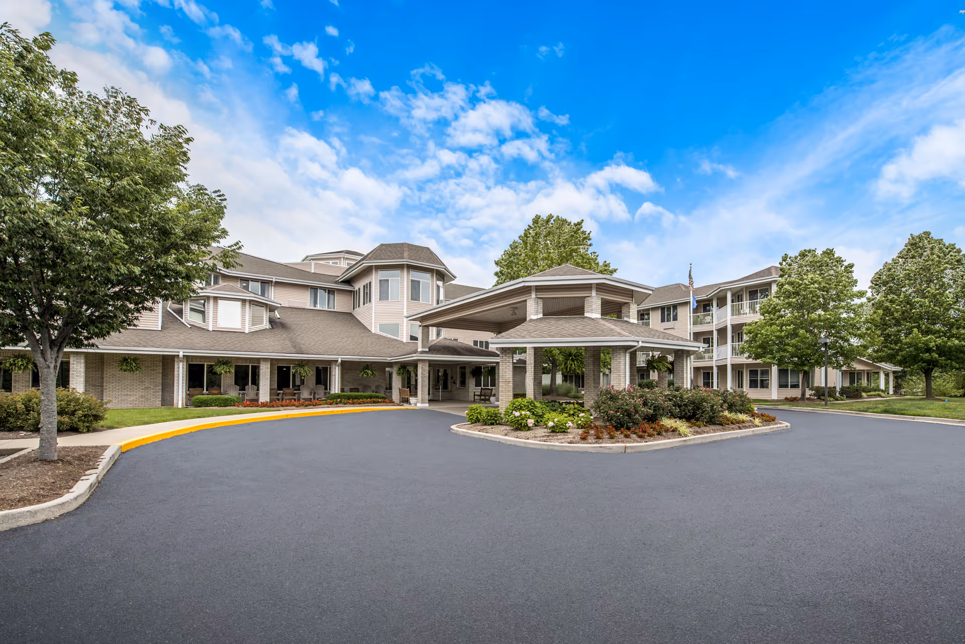 Exterior view of Holiday Redbud Hills with porte-cochere entrance and circular driveway.