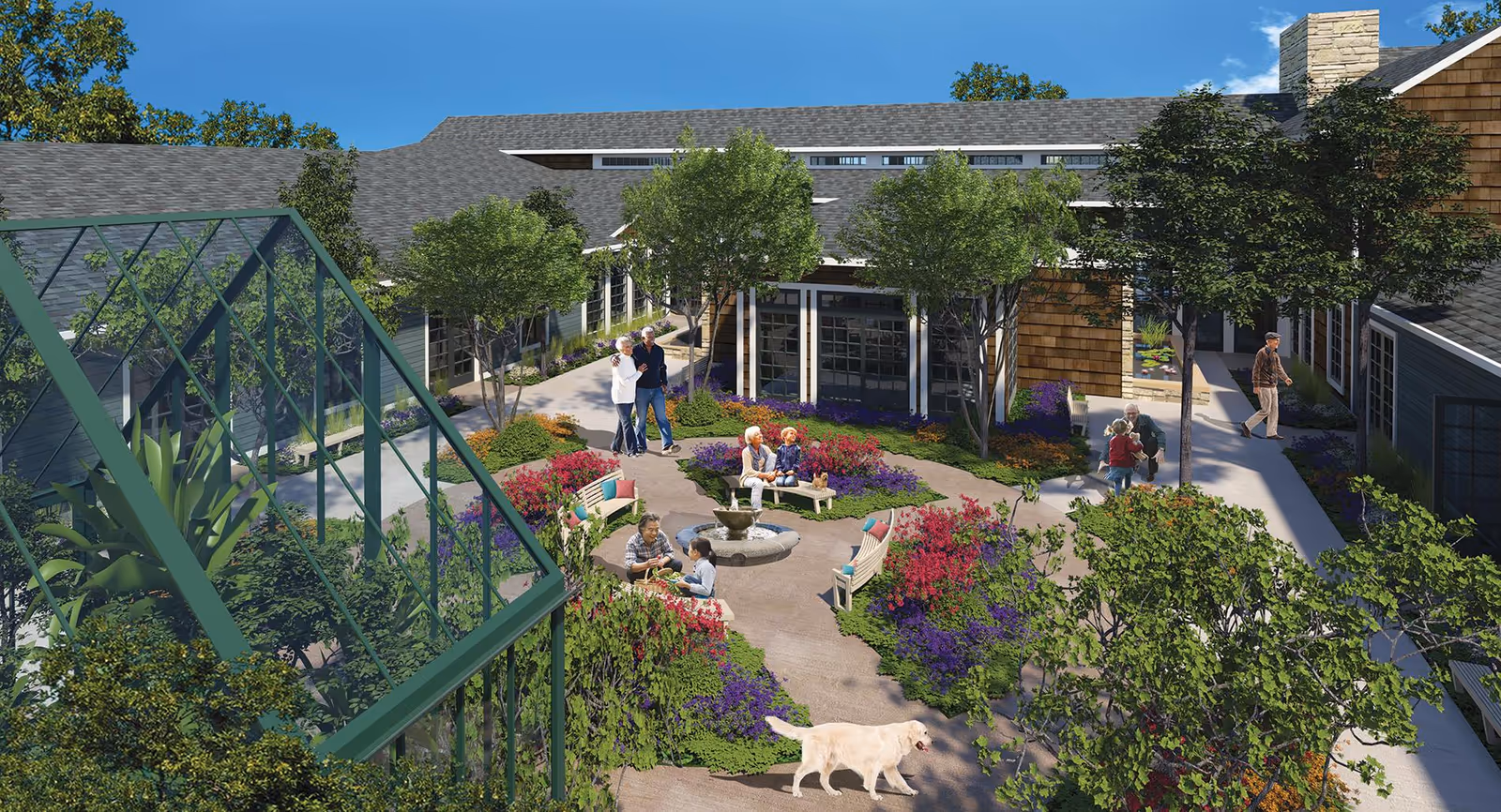 Outdoor courtyard area at Madison at The Range featuring a circular garden with colorful flowers and shrubs, several benches around a central fountain, mature trees providing shade, a greenhouse structure on the left, and a few people and a dog enjoying the space.