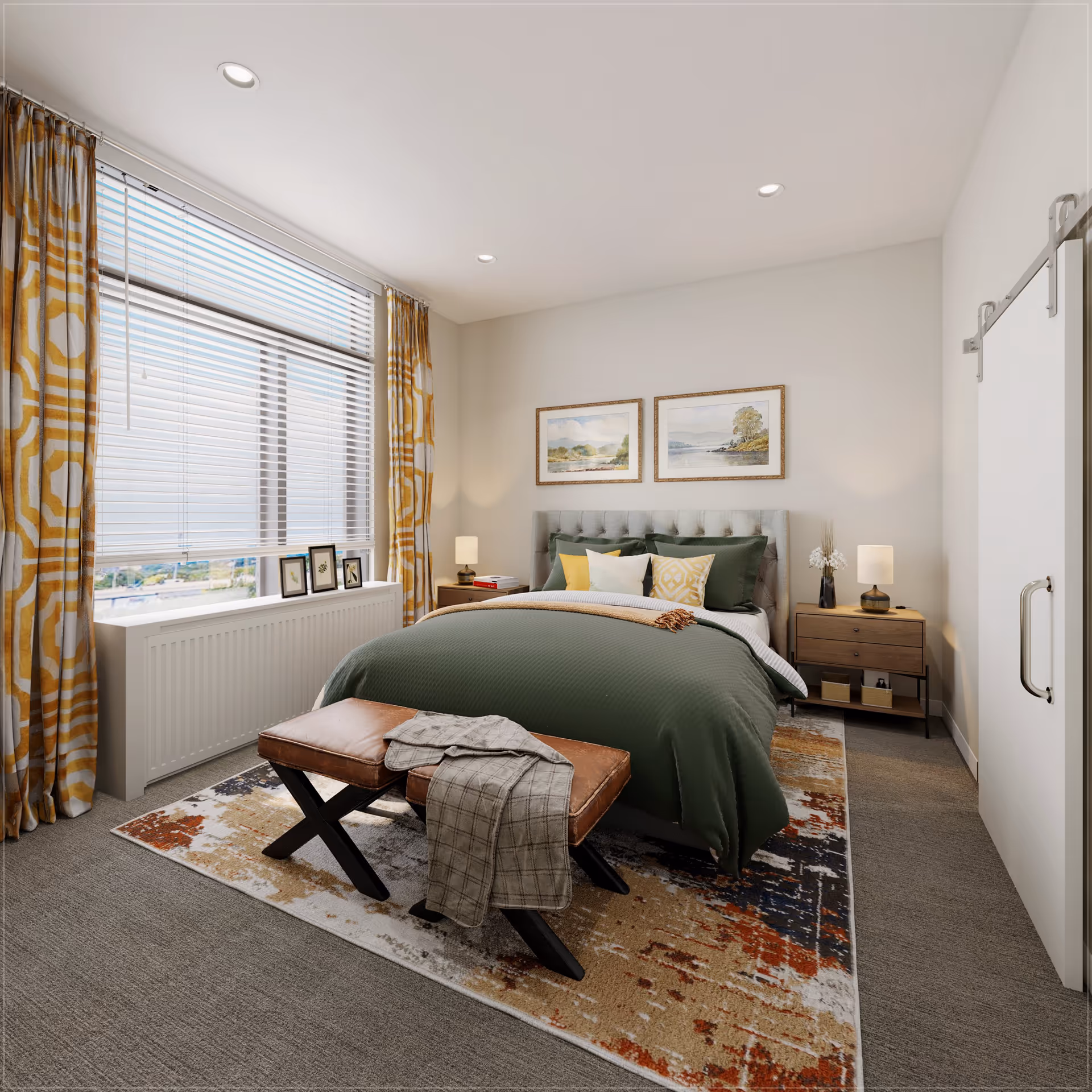A cozy bedroom with a large window covered by white blinds and yellow patterned curtains. The room features a bed with a green comforter, multiple pillows, and a tufted headboard. Two framed landscape paintings hang above the bed. There are two wooden nightstands with lamps and decorative items on either side of the bed. A brown leather bench with a folded blanket is placed at the foot of the bed on a multicolored area rug. The walls are painted light gray, and there is a sliding barn door on the right side of the room.