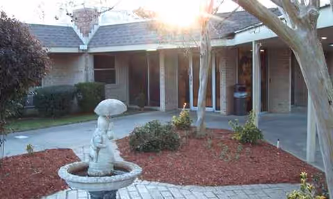 Exterior view of the North Mobile Nursing and Rehabilitation Center entrance with a fountain and landscaping