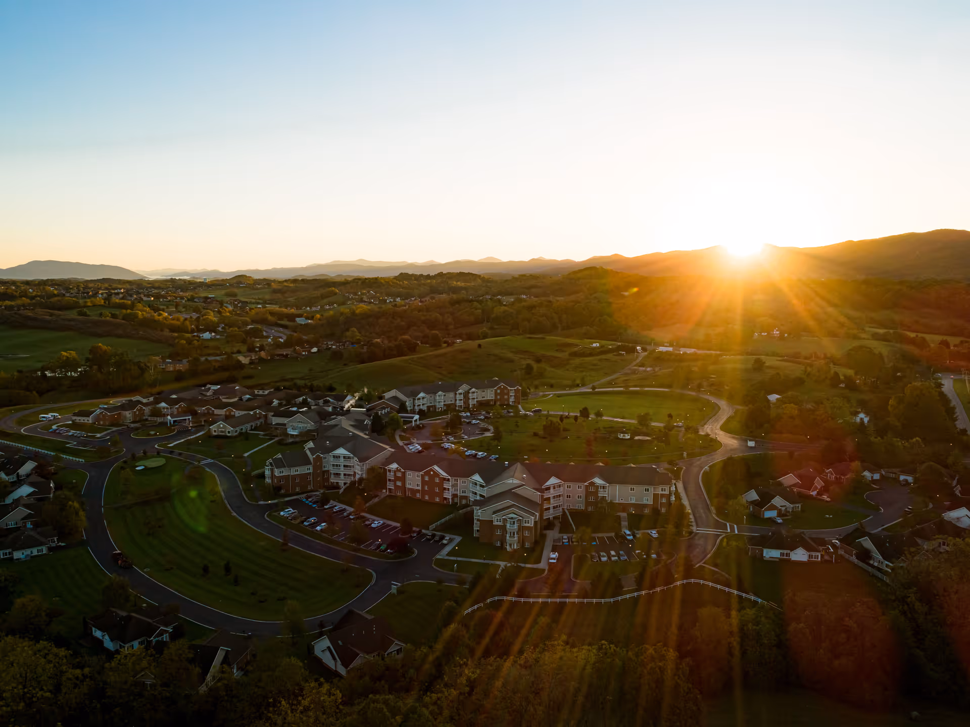 Aerial view of The Glebe Retirement Community campus and surrounding rolling countryside at sunset.
