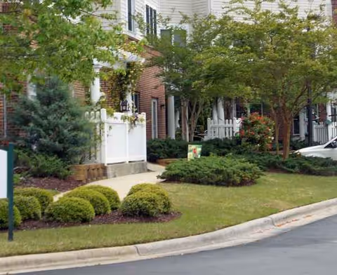 Front exterior of Cypress Glen Retirement Community with landscaped shrubs and trees