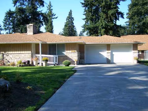 Single-story residential-style facility with a driveway, lawn, and two garage bays.