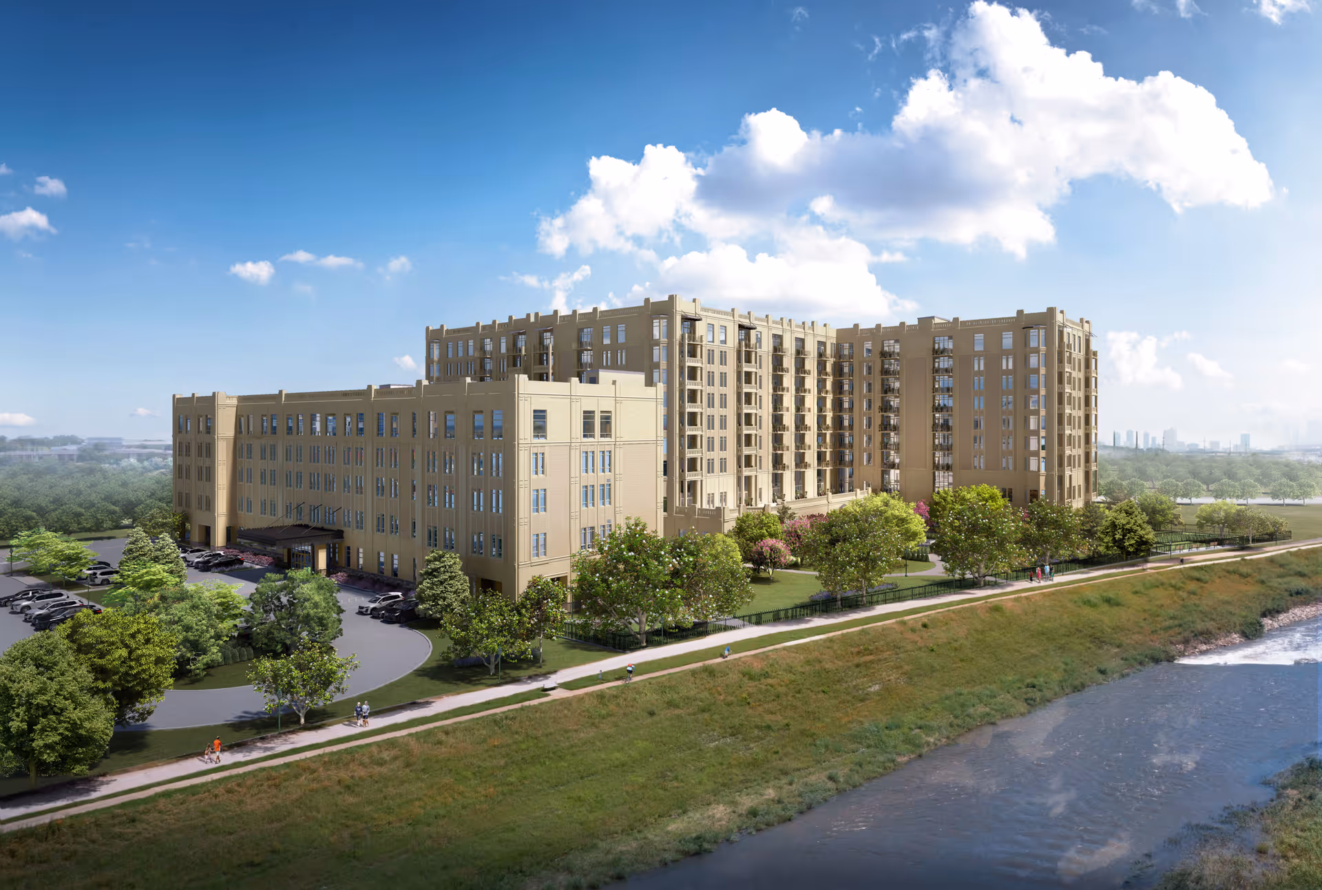 Large multi-story senior living building beside a river with landscaped grounds and a walking path.