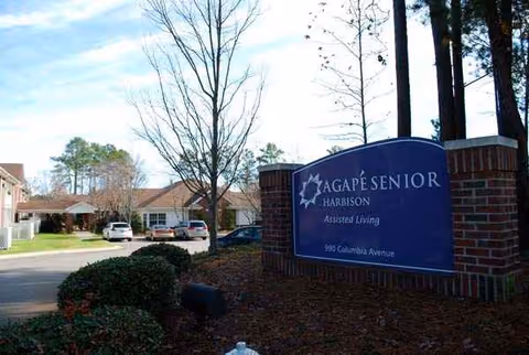 Blue sign reads Harbison Shores Assisted Living and Memory Care at brick entrance.