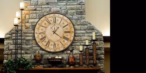 Stone fireplace with a large round clock and decorative candles on the mantel.