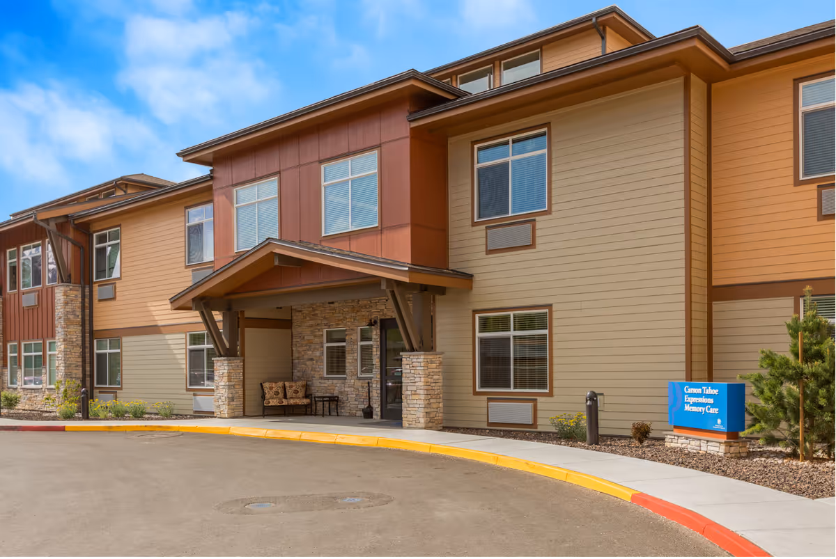 Exterior view of Sierra Basin Memory Care facility showing entrance, seating, and signage.