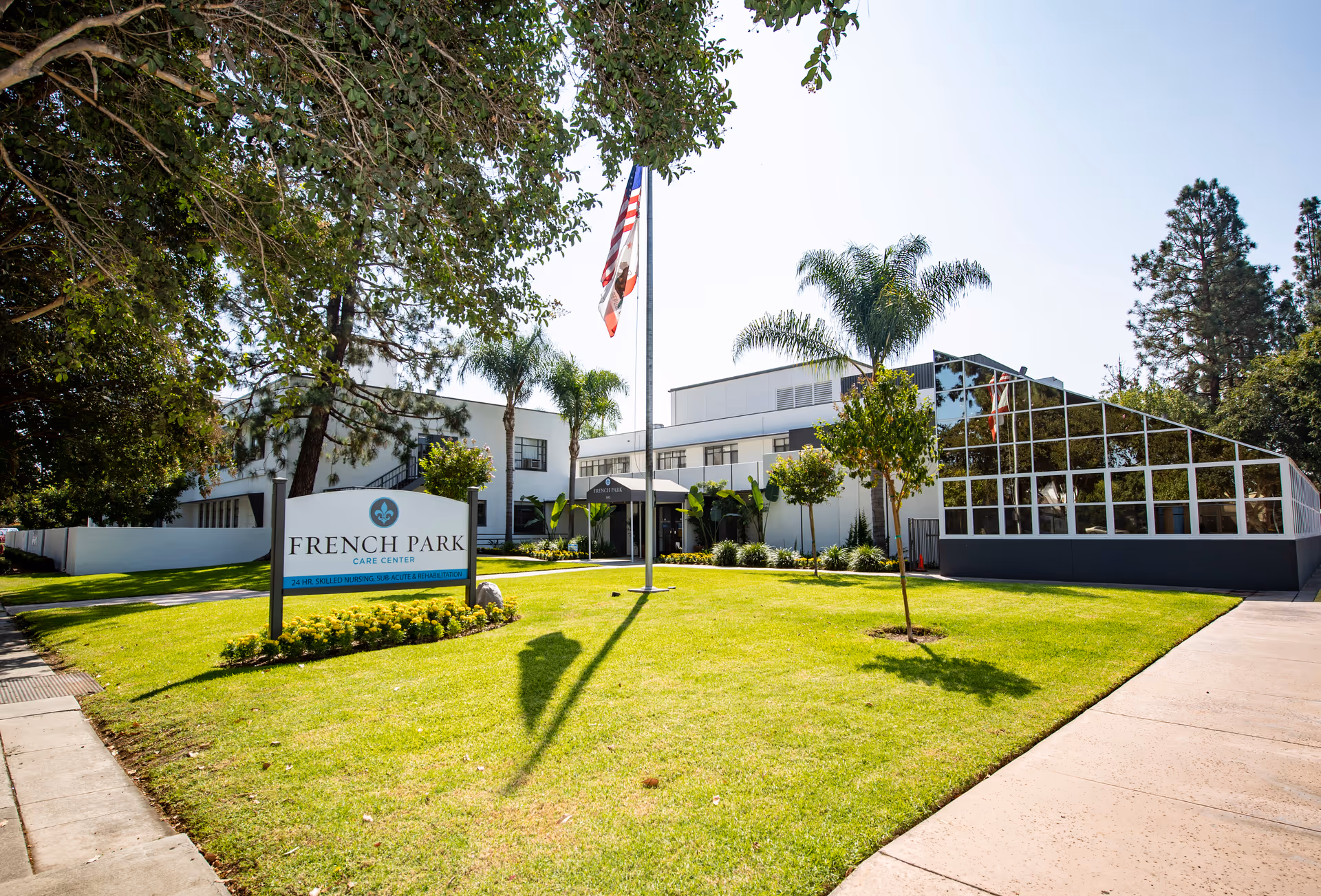 Front exterior of the French Park Care Center showing the building, lawn, entrance sign, and flagpole.