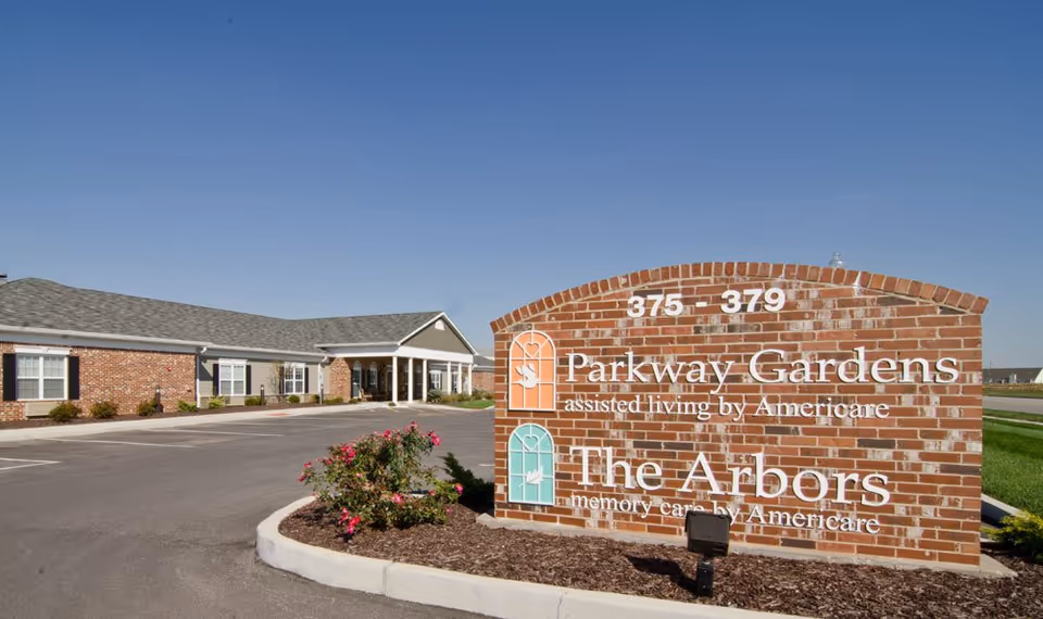 Exterior view of Parkway Gardens sign with building entrance in the background.