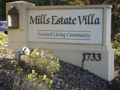 Mills Estate Villa sign reads Assisted Living Community with the number 1733 beside landscaping