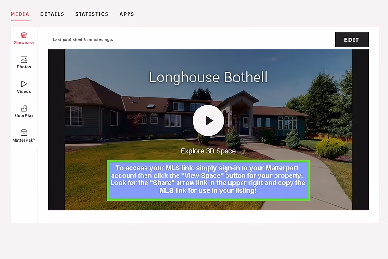 Exterior view of Longhouse Bothell building with a walkway leading to the entrance, surrounded by green grass, shrubs, and trees under a clear blue sky.