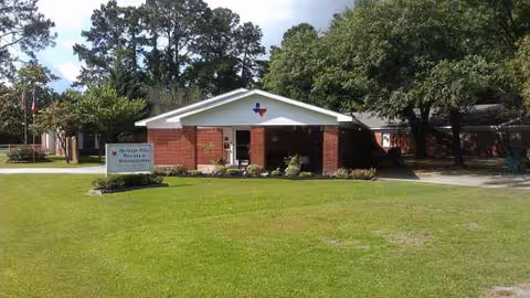 Front view of a brick nursing facility with a covered entrance and green lawn.