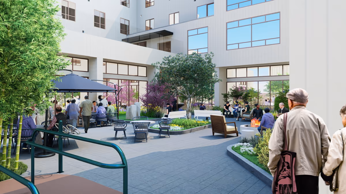 Courtyard patio with seating, planters, and seniors socializing outside a modern multi-story senior living building.