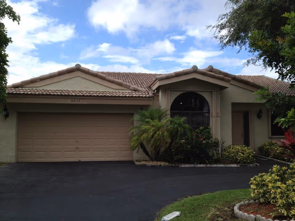 Sunshine Assisted Living facility facade with tan stucco, arched window, and landscaped driveway