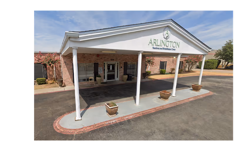 Front entrance of Arlington Residence and Rehabilitation Center with a covered drive and potted plants.