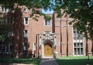 Brick building exterior with arched entrance and wooden door.