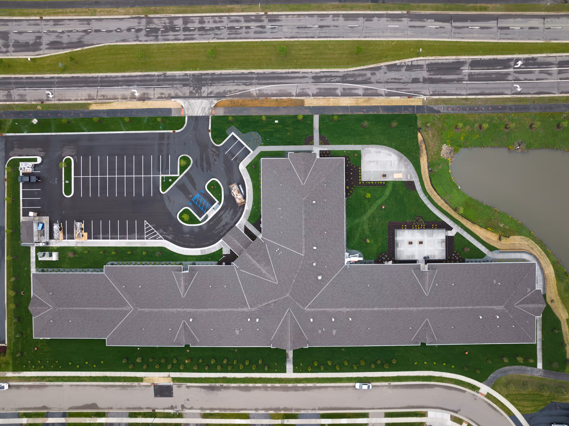 Aerial view of Boden Senior Living building with surrounding parking lot, landscaped grounds and adjacent pond.