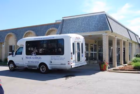 Front exterior of Meadowbrook South Campus with a white bus parked out front