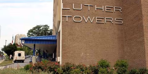 Exterior view of Luther Towers II building with blue entrance awning and landscaped driveway.