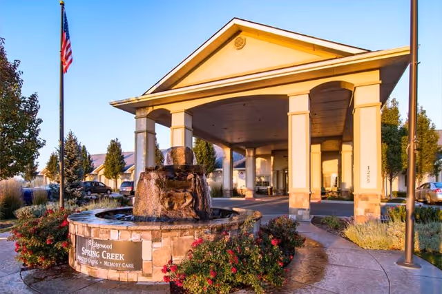 Front entrance of Edgewood Spring Creek with a covered porte-cochere, fountain and flagpole.