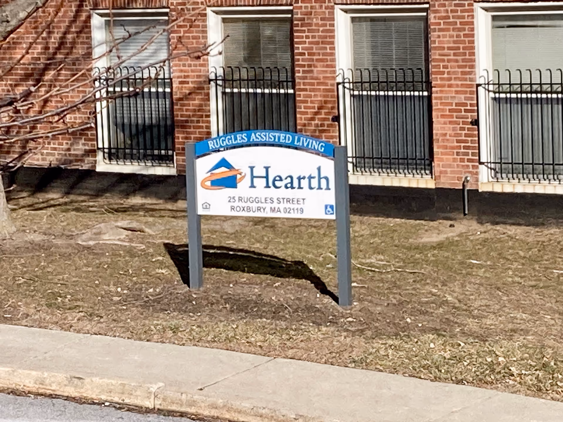 Outdoor sign reading 'Hearth' for Ruggles Assisted Living in front of a brick building.