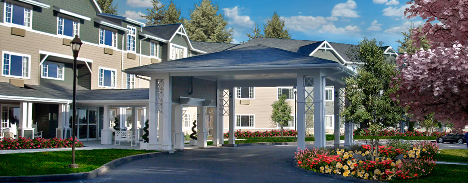 Exterior view of Ledgewood Bay Assisted Living facility showing a large covered entrance with white pillars, surrounded by landscaped flower beds and trees, with a multi-story beige building in the background under a blue sky with clouds.