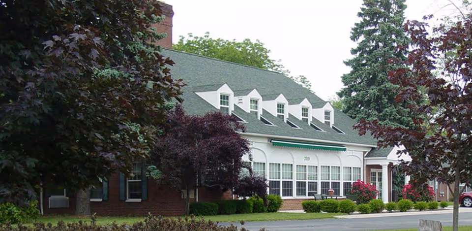 Exterior of Majestic Care Toledo Assisted Living building with green awning and brick facade
