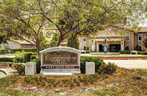 Exterior view of Conservatory Senior Living at Plano with sign and main entrance.
