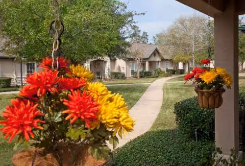 Front walkway through landscaped grounds with hanging flower baskets and cottages.