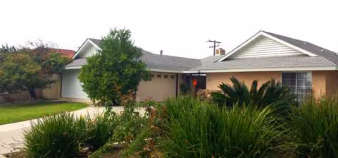 Front exterior of a single-story senior living home with manicured front yard