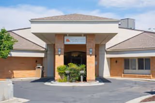 Front exterior view of Monument Health Murray Creek facility with a covered entrance, brick walls, and a driveway in front.