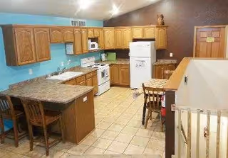 Residential kitchen in Willow Winds Living with wooden cabinets, appliances, and an island.