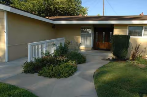 Front exterior view of Premier Residential Care at GreenMill with walkway and landscaped entry