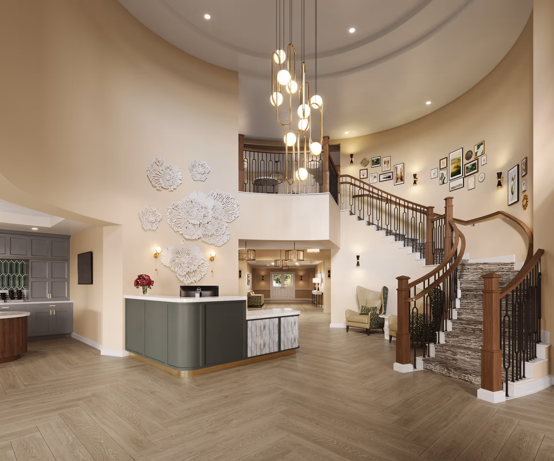A spacious and elegant lobby area with a curved staircase featuring wooden handrails and carpeted steps. The walls are decorated with framed pictures and white floral wall art. There is a modern reception desk with a computer and a vase of flowers. The floor has a light wood finish, and a contemporary chandelier with multiple hanging lights is suspended from the high ceiling.
