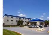 Exterior view of Lorien Columbia senior living facility with parked cars and blue canopy entrance.