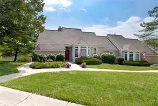 Front exterior of Evergreen Retirement Community, a single-story building with manicured lawn and walkway.