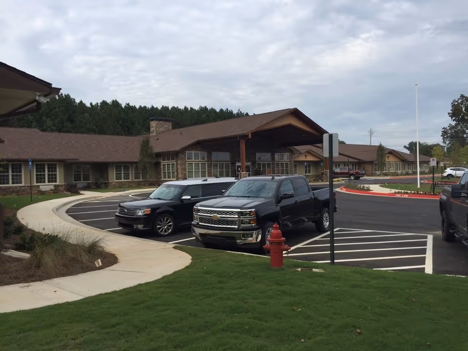 Front view of The Retreat at Canton with parked cars and a brown single-story building