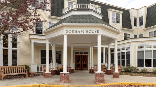 Stone steps lead to Gorham House front doors beneath a covered porch with columns.