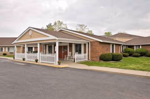 Exterior view of Mitchell Manor facility with brick walls, covered entrance, and landscaping.