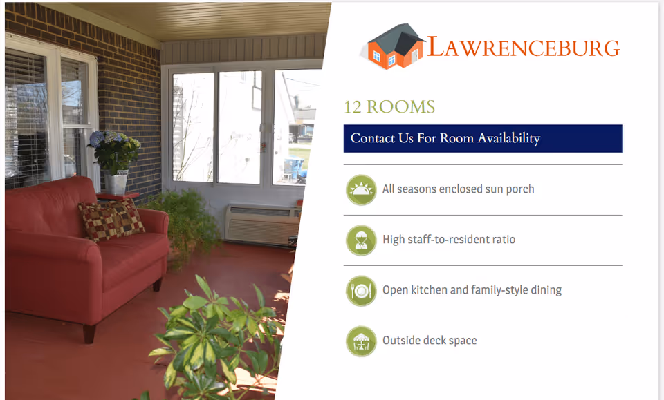 A cozy enclosed sun porch featuring a red sofa with decorative pillows, potted plants, and large windows allowing natural light to fill the space.