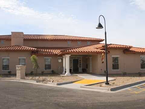 Exterior view of Barton House senior living facility with entrance and walkway.