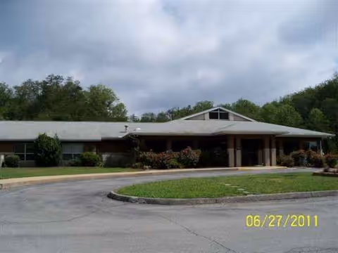 Low, single-story building with a covered entrance and manicured landscaping.