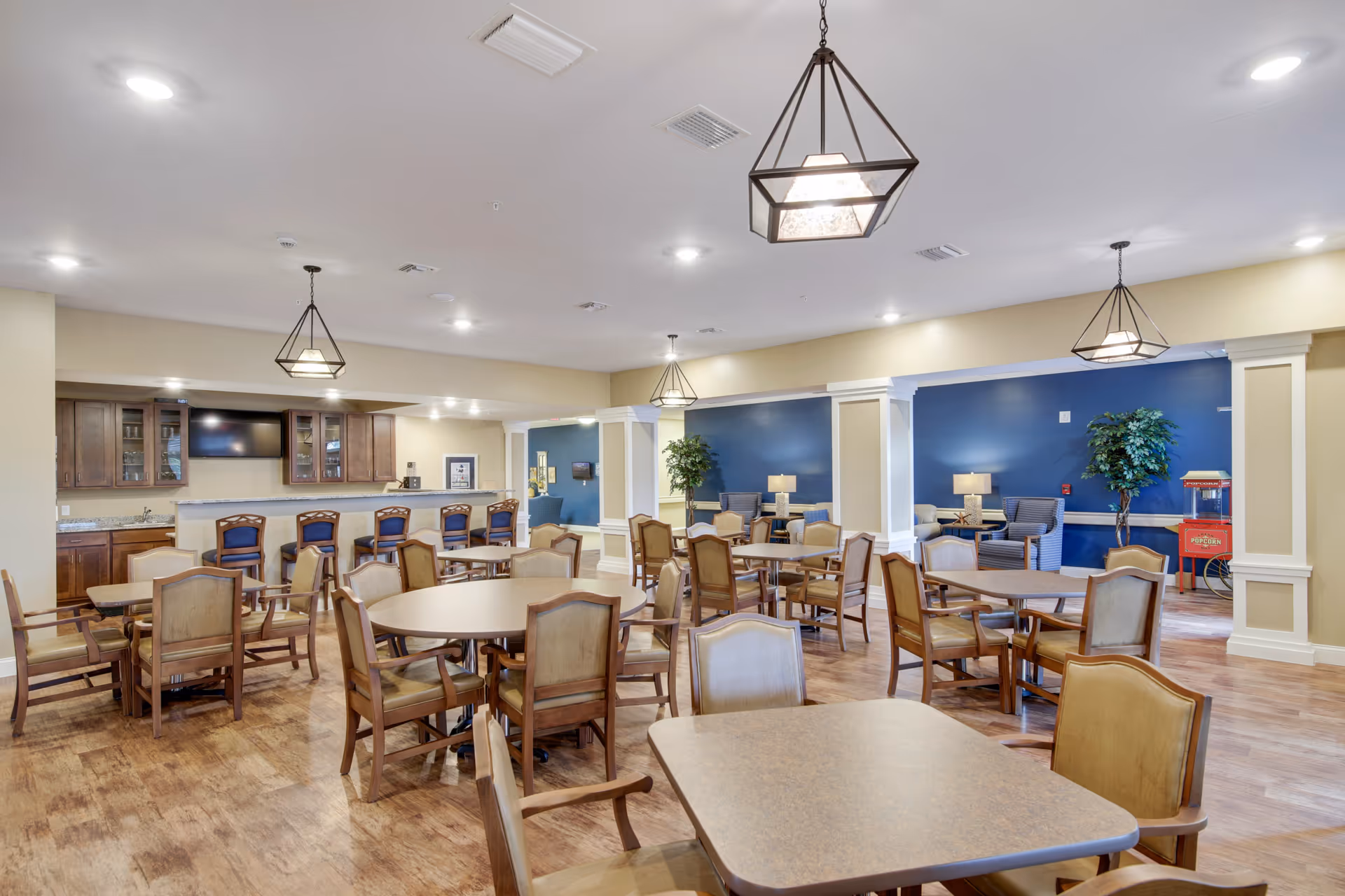 Interior dining area with round tables, wooden chairs, and a blue accent wall.