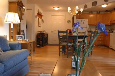 Cozy open living area with a couch, coffee table, dining table, and kitchen.