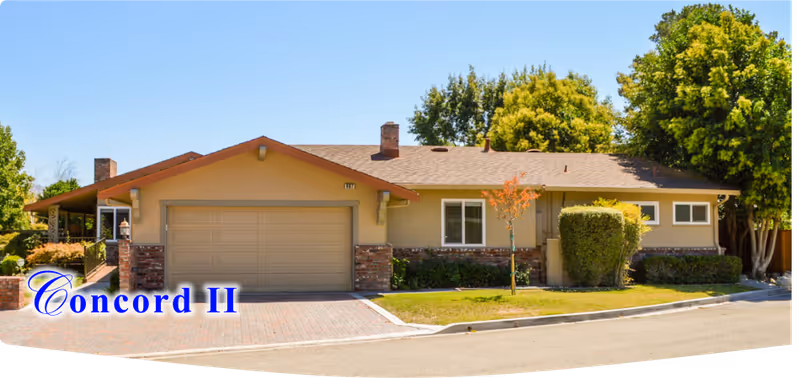 Single-story residential house exterior with a two-car garage and manicured lawn.