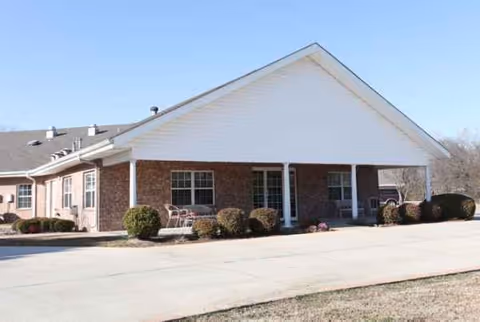 Exterior view of Cedar Creek Lodge Boutique Senior Living building with entry and shrubs.